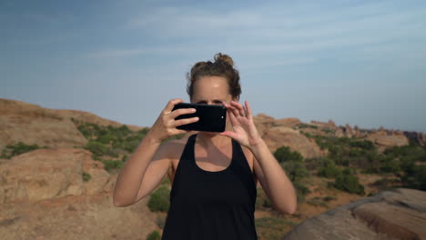 Frau-Fotografiert-Mit-Smartphone-In-Der-Wüste-Bei-Sonnenuntergang-Im-Urlaub