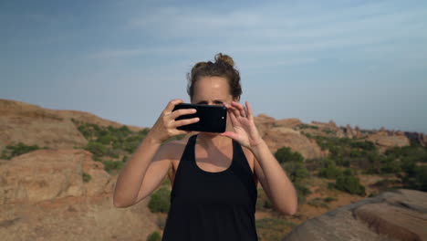 Mujer-Tomando-Fotografías-Con-Un-Teléfono-Inteligente-En-El-Desierto-Al-Atardecer-De-Vacaciones