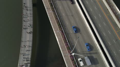 Volando-Sobre-Los-Puentes-De-Tráfico-De-Automóviles-De-Singapur-En-El-Centro-De-La-Ciudad,-Panorámica-Hasta-El-Centro-De-La-Ciudad,-Revelando-Todos-Los-Edificios-Famosos,-Como-Merlion,-Hotel-Fullerton,-Rascacielos,-Torre