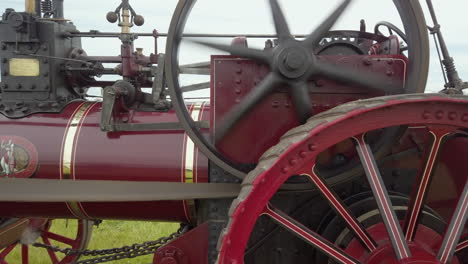 Close-up-of-the-side-of-a-red-vintage-traction-engine-in-operation