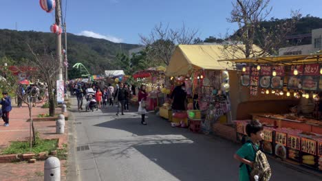 Las-Familias-Disfrutan-De-Los-Puestos-De-Mercado-En-El-Festival-De-Los-Cerezos-En-Flor-De-Nago,-Okinawa,-Japón