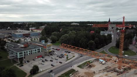 Tolle-Drohnenaufnahme-Vom-Rückwärtsfliegen-Unter-Einem-Kran-Auf-Einer-Baustelle