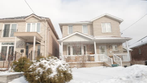 POV-shot-driving-past-detached-houses-in-the-suburbs-of-Toronto-on-a-bright-winter-day