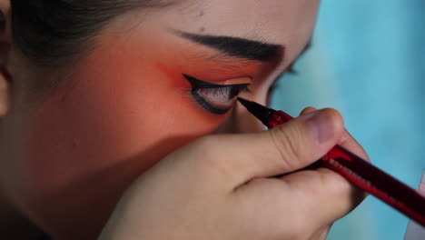 Close-up-of-Chinese-Opera-actress-as-she-applies-make-up-backstage