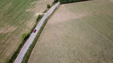 Aerial-view-of-red-car-driving,-Cork,-Ireland,-21-July