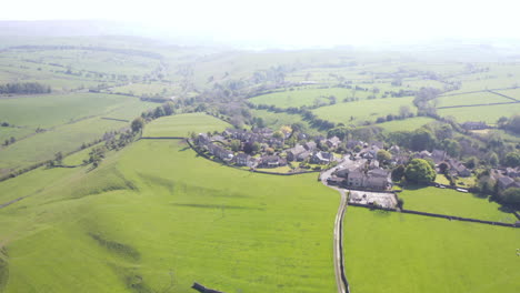 Aerial-Shot-Fading-In-to-Reveal-Small-Yorkshire-Village-and-Sheep-being-Herded-on-Sunny-Day-in-Yorkshire,-England