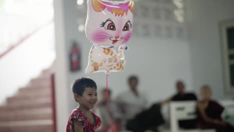 Niño-Birmano-Feliz-Jugando-Con-Un-Globo-Gatito