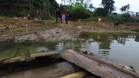 Una-Balsa-De-Ferry-Tirada-Hacia-La-Orilla-Cerca-De-Un-Pueblo-De-Pescadores-En-El-Lago-Thac-Ba,-Vietnam