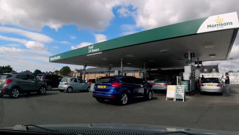 Driving-into-Morrisons-petrol-station,-waiting-at-the-pay-at-the-pump-while-the-customer-in-front-refuels-his-car