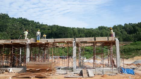 Construction-workers-installing-timber-form-works-and-rain-water-down-pipes-at-the-construction-site