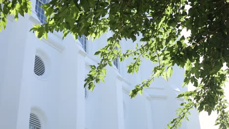 Toma-Reveladora-Del-Templo-De-San-Jorge-Detrás-De-Un-árbol-Verde-Con-Destellos-Solares-Cinematográficos-También.