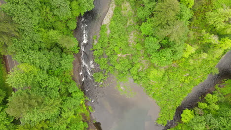 Aerial-drone-shot-of-the-beautiful-Washougal-River-during-day-time,-surrounded-by-forest