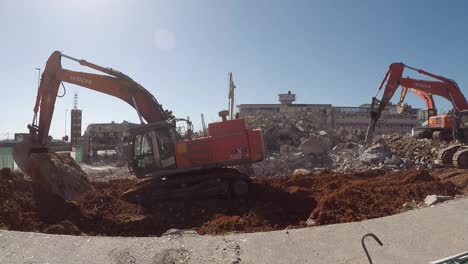 Workers-erect-a-fence-for-restricted-area-at-Ross-Demolition-site-next-to-Hitachi-excavator-heavy-machinery-ZX520LCH-corner-of-main-road-Victoria-road,-M4-and-Dickens-road-in-Salt-River