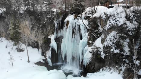 Teilweise-Gefrorener-Wasserfall,-Der-Im-Winter-In-4k-In-Einen-Schneebedeckten-Bach-Fließt