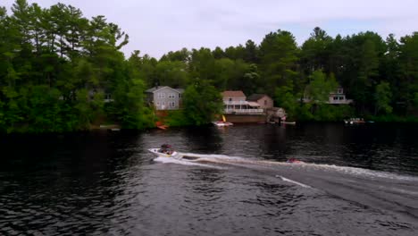 Kids-riding-on-a-tube-being-pulled-behind-a-speed-boat-on-a-pond-on-a-beautiful-summer-day