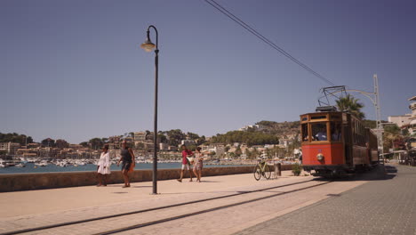 Old-vintage-orange-tram-in-Soller-running-along-the-town-on-a-sunny-day