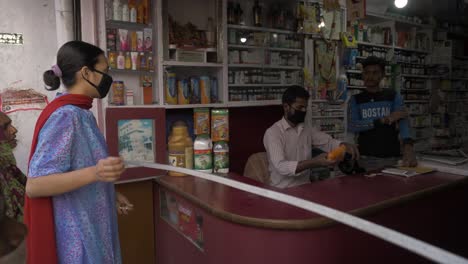 Una-Niña-Que-Llevaba-Una-Máscara-Mientras-Visitaba-Una-Tienda-De-Medicamentos-O-Un-Taller-Médico-Manteniendo-El-Distanciamiento-Social-Durante-El-Cierre-Impuesto-En-El-Estado-De-Bihar,-India.