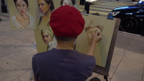 Dibujos-De-Retratos-Artísticos-Realizados-Por-Un-Artista-Callejero-Asiático,-Vista-Detrás,-Acera