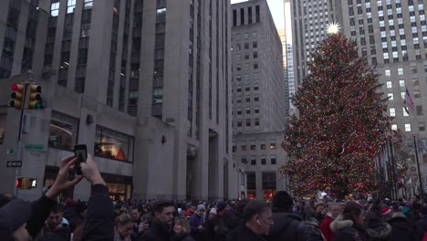 Rockefeller-Center-Christmas-Tree,-Closeup-Eye-Level-Angle-with-People-Walking-By,-Families-Spending-Time-Together-and-Taking-Photos-of-the-Famous-Tree