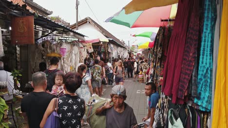 Turistas-Y-Gente-Local-Haciendo-Turismo-Y-Comprando-En-Un-Colorido-Mercado-Abierto-Que-Vende-Ropa-Y-Recuerdos