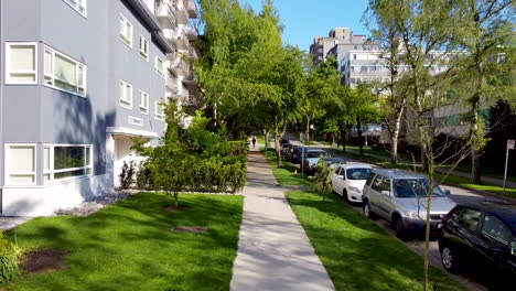 Quiet-neighborhood-with-parked-cars-bumper-to-bumper-on-a-beautiful-summer-day-adjacent-to-sidewalk-with-many-lowrise-apartments