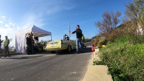 Boxencrews-Inspizieren-Die-Autos-Und-Halten-Beim-Boxenstopp-Am-Hügel-In-Imtahleb,-Malta,-Mit-Feuerlöscher-Am-Straßenrand---GoPro-Zeitraffer