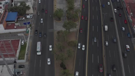 Tilt-Up-Aerial-View-of-Traffic-Around-Torres-de-Satelite,-Mexico-City-Metropolis-Landmark