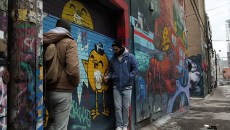 Freunde-Machen-Fotos-In-Der-Graffiti-Gasse-In-Der-Innenstadt-Von-Toronto