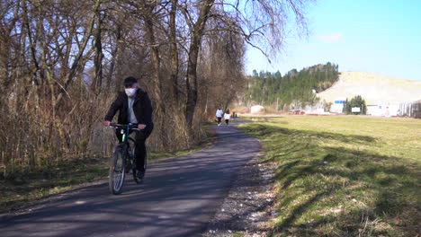 Hombre-Que-Llevaba-Máscara-Protectora-Mientras-Andaba-En-Bicicleta-Cerca-De-Bratislava,-Eslovaquia-Durante-La-Pandemia-Del-Coronavirus---Cámara-Lenta