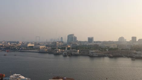 This-is-an-aerial-view-of-the-Dubai-skyline,-Deira-and-Old-Dubai,-with-Burj-Khalifa-and-Dubai-Frame-appearing-in-the-horizon