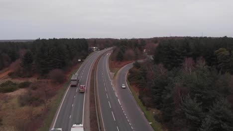 Clip-De-Drones-Aéreos-En-Movimiento-Lento-De-Una-Carretera-Con-Tráfico-En-El-Campo-En-Inglaterra,-Thteford