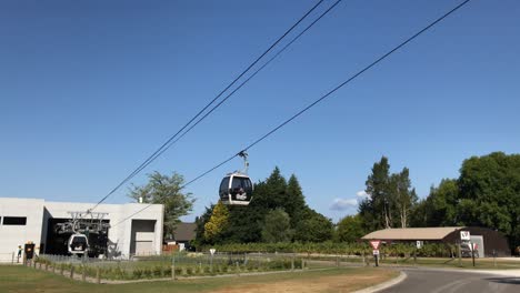 Zwei-Skyline-Gondeln-Gleiten-Entlang-Der-Kabel-Unter-Einem-Klaren-Blauen-Himmel-In-Rotorua,-Neuseeland,-Aneinander-Vorbei