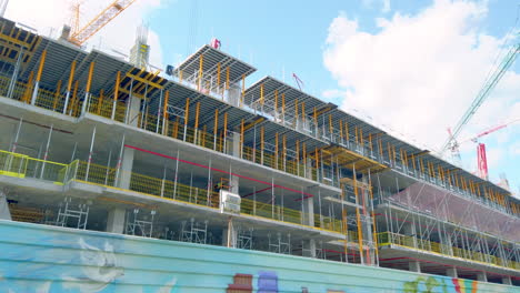 Worker-on-construction-site-with-cranes-and-scaffolding