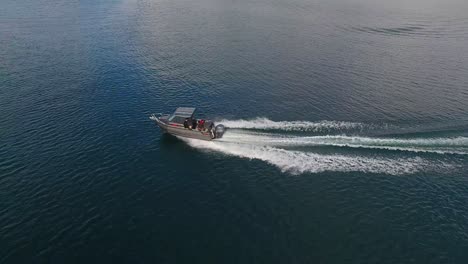 Aerial-Panning-shot-of-a-fishing-boat-navigating-on-Taupo-Lake,-New-Zealand