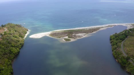 view-from-a-drone-of-a-sandbank-blocking-a-river-to-go-into-the-sea-like-a-natural-dam,-during-a-sunny-day