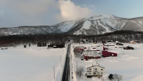 4K-Drohnenaufnahmen-Eines-Verschneiten-Skigebiets-Und-Dorfes-In-Niseko,-Japan-Während-Des-Sonnenuntergangs-Und-Der-Goldenen-Stunde