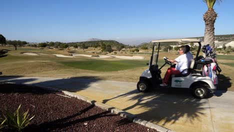 Blick-über-Den-Golfplatz-Im-Vistabella-Golf-Club,-Während-Ein-Buggy-Mit-Golferinnen-An-Bord-Vorbeifährt