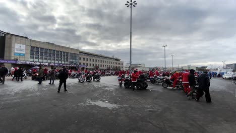 Motorcyclists-dressed-as-Santa-Clauses-during-a-charity-motorcycle-ride-through-the-city,-A-static-shot-in-the-square