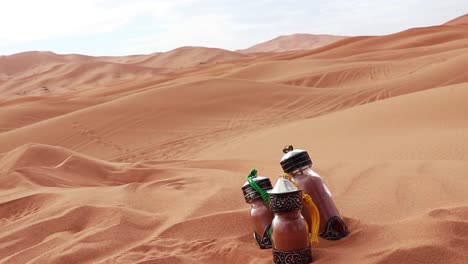 Elaborately-decorated-glass-bottles-with-smoothies-sitting-in-desert-sand