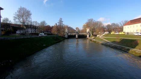 Wide-shot-tilt-up-Ljubljanica-river-water-flows-under-sluice-gate-in-Ljubljana-city,-Slovenia