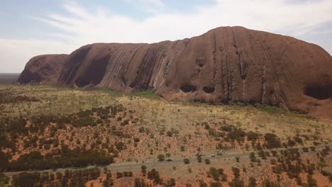 Uluru-Australia,-Drone-panning-left-to-show-view-of-the-spectacular-Ayres-Rock