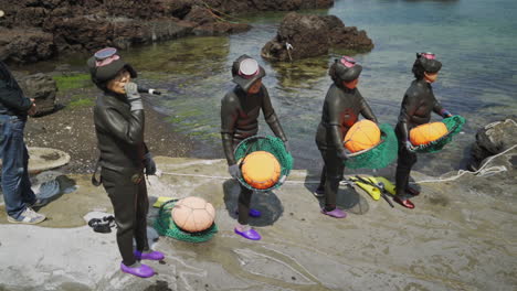 Haenyeo-Realizando-Un-Ritual-De-Danza-Y-Canción-Previo-Al-Buceo-Con-Sus-Herramientas-Y-En-Sus-Trajes-De-Neopreno.