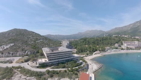 Imágenes-Aéreas-De-Drones-Hacia-Un-Hotel-Abandonado-En-La-Playa-De-Kupari,-Croacia