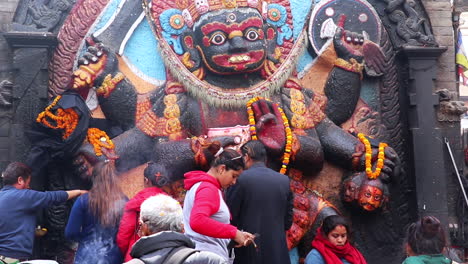 People-offering-prayers-and-worship-the-statue-of-Kaal-Bhairava-in-Kathmandu,-Nepal