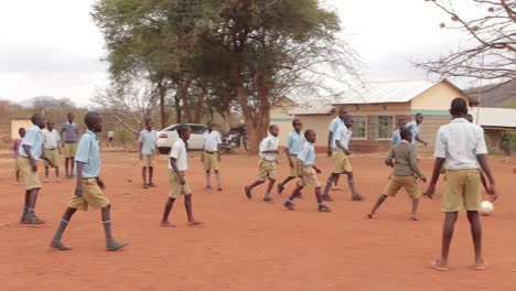 Niños-De-Escuela-Jugando-Al-Fútbol-En-Una-Zona-Seca,-Kenia-África