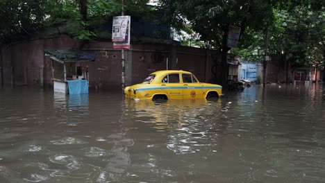 Taxi-partly-submerged-in-the-water-logged-streets-of-Kolkata,-West-Bengal,-India
