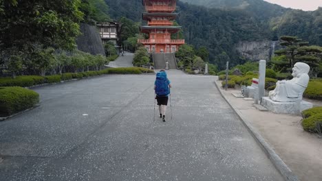 Seiganto-ji-pagoda-with-falls-in-a-distance,-one-person,-slow-motion-24fps-out-of-50fps