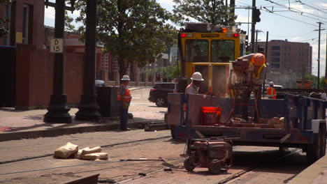 A-Construction-worker-is-working-in-the-back-of-a-truck-while-others-are-working-in-the-background