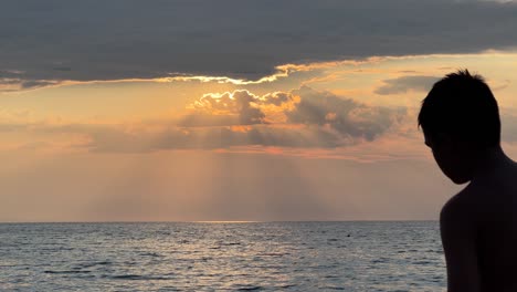 Silhouette-of-a-young-boy-passing-in-front-of-a-beautiful-sunset