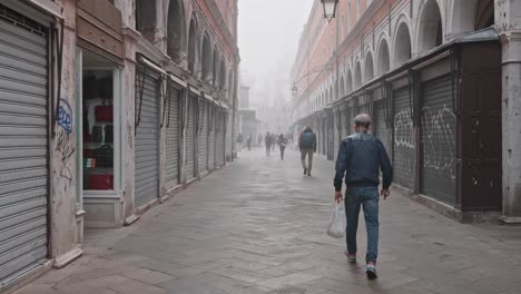 Cámara-Lenta-De-Gente-Detrás-Caminando-Por-La-Calle-De-Venecia-Cerca-Del-Puente-De-Rialto-En-Una-Mañana-Brumosa-Y-Cambiante